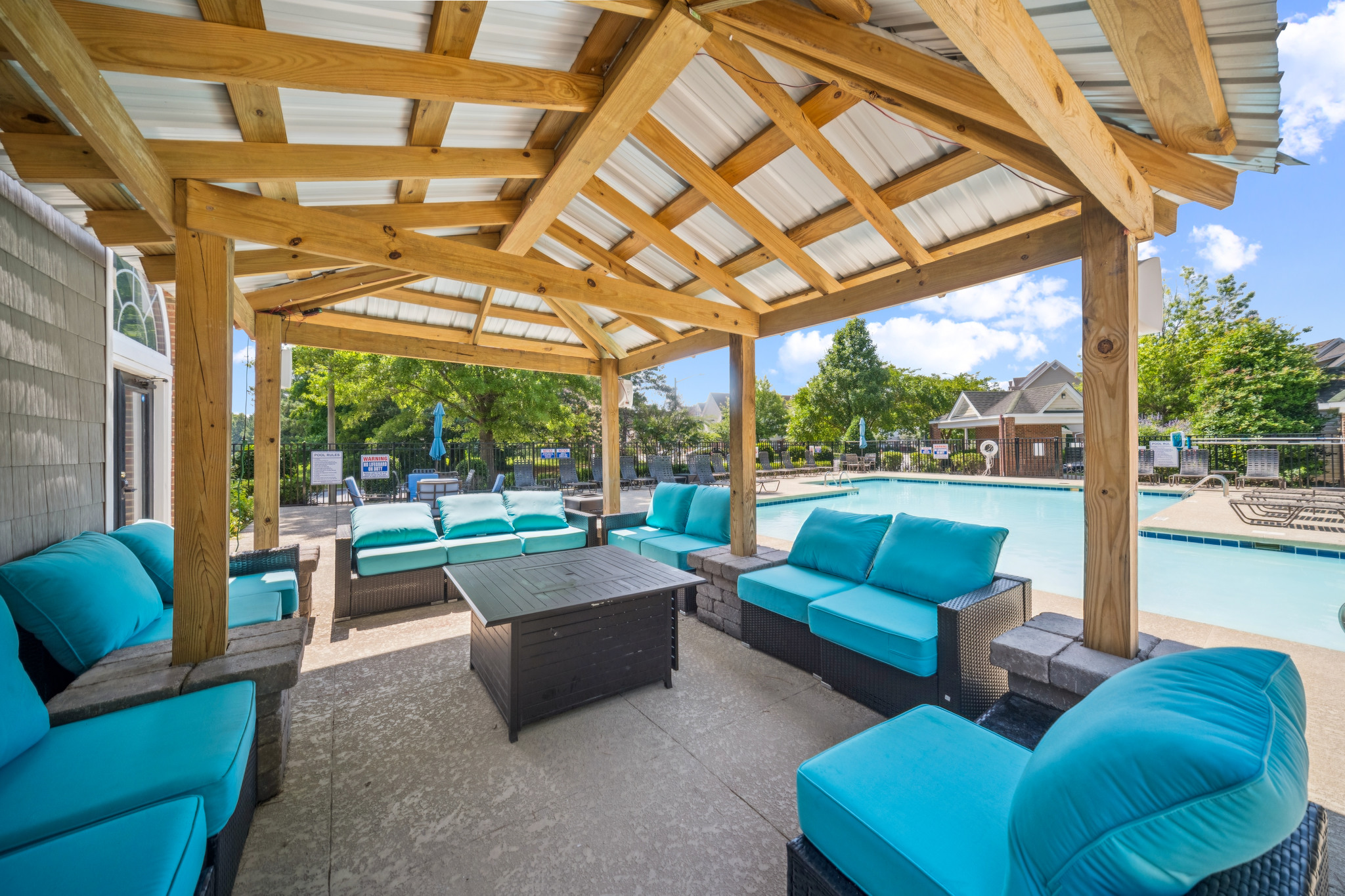 a patio with a pool and blue furniture