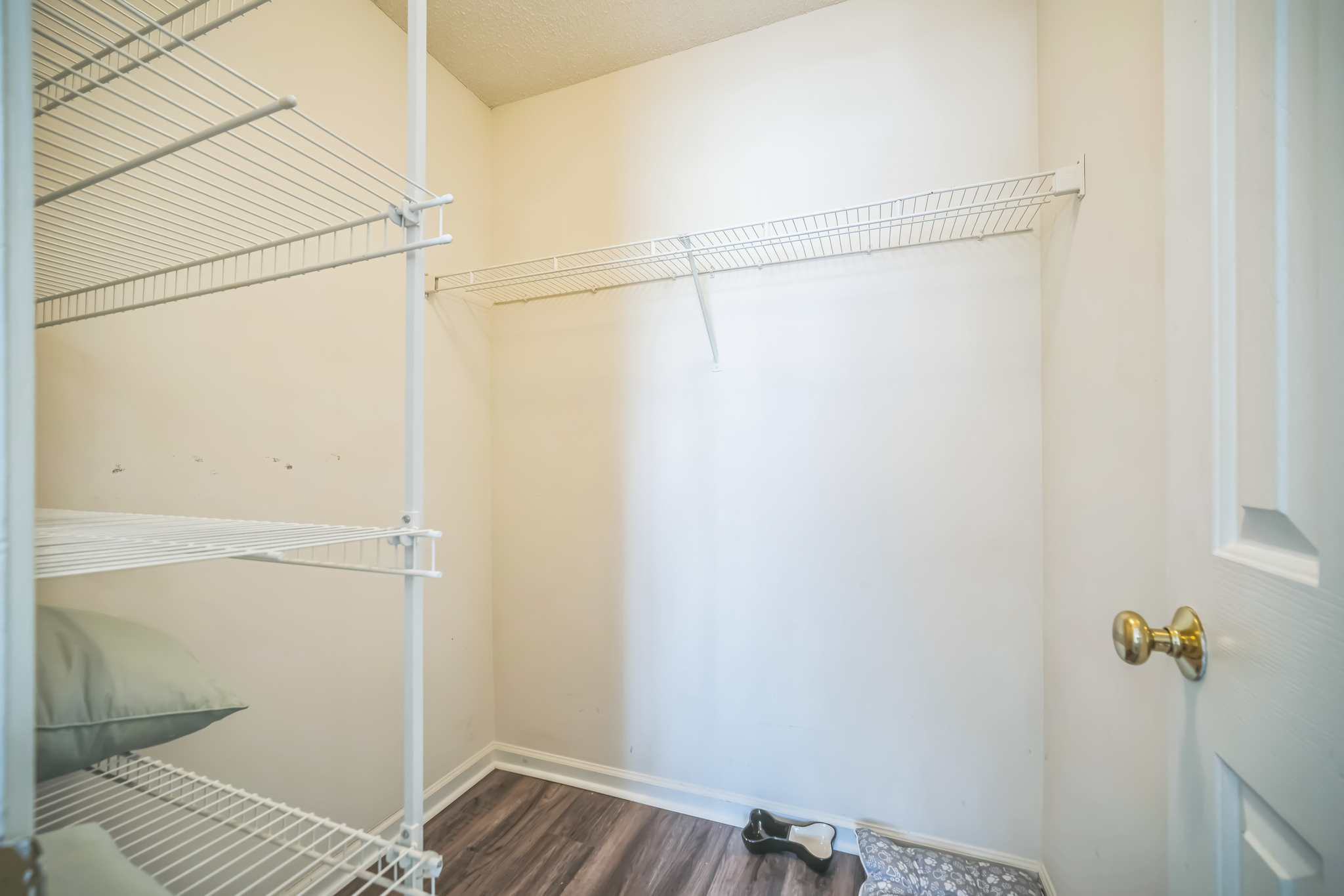 a room with white shelves and a wood floor